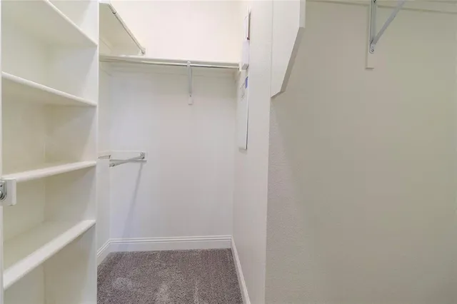 a view of walk in closet with empty racks