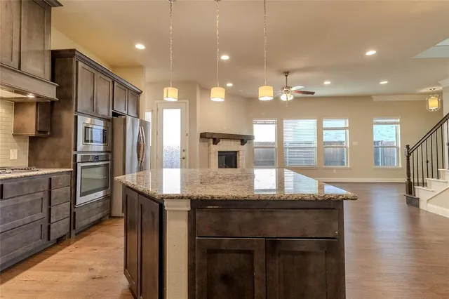 a kitchen with stainless steel appliances granite countertop a refrigerator and a sink