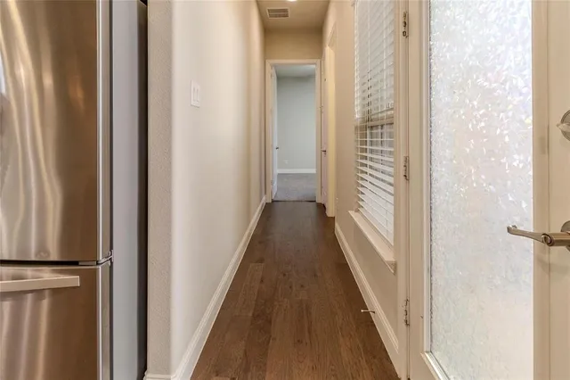 a view of a hallway with wooden floor and staircase