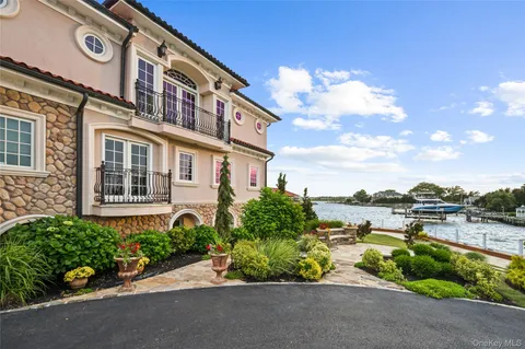 a living room with furniture a chandelier a large window and potted plants