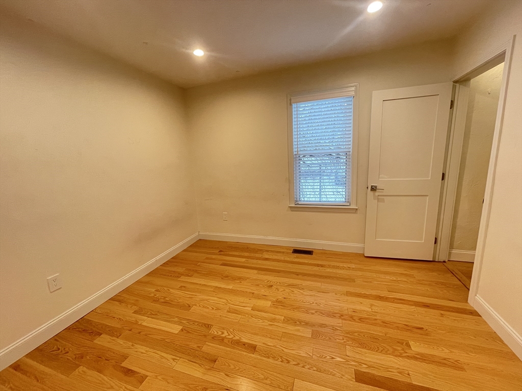 95 Phillips Street, Unit 1 Methuen, MA 01844 - Photo 3 of 10 a view of an empty room with wooden floor and a window