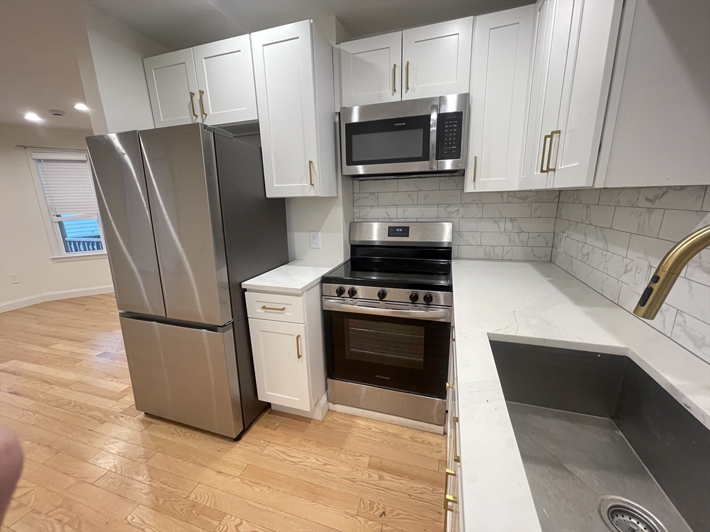 95 Phillips Street, Unit 1 Methuen, MA 01844 - Photo 9 of 10 a kitchen with a refrigerator stove and microwave