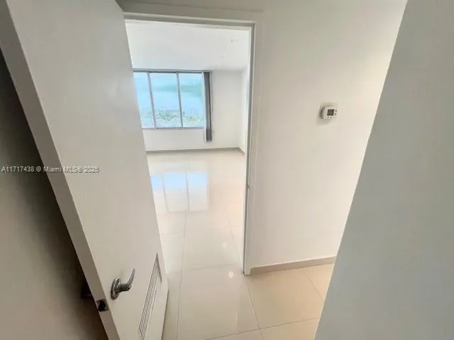 a large white kitchen with stainless steel appliances a large counter top and a stove