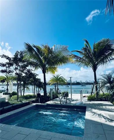 a large kitchen with stainless steel appliances kitchen island granite countertop a sink and white cabinets