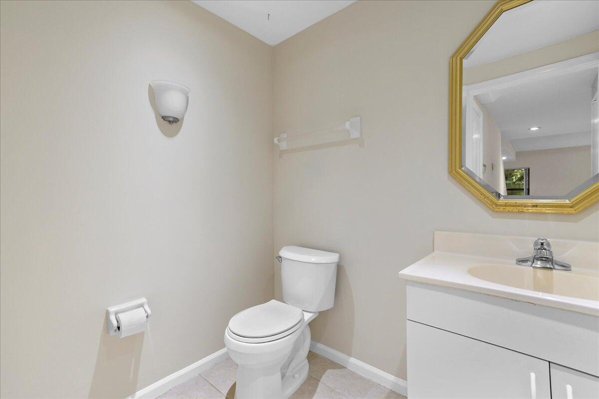 41 Uno Lago Drive Juno Beach, FL 33408 - Photo 9 of 31 a bathroom with a toilet a sink and mirror