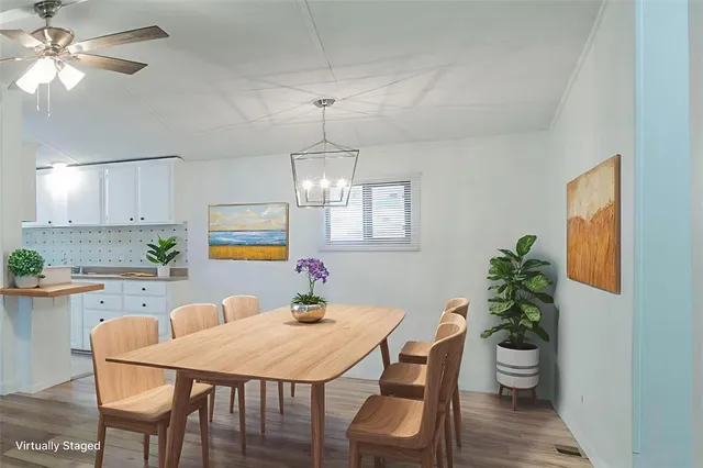 a view of a dining room with furniture a chandelier and wooden floor