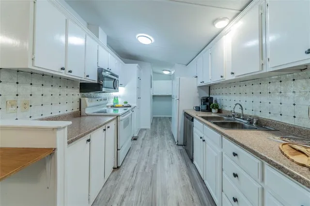 a kitchen with granite countertop a sink and cabinets