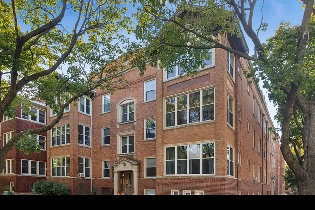 a front view of a building with a tree