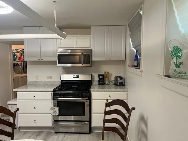 a kitchen with granite countertop a stove and a microwave