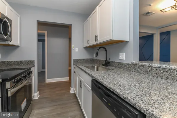 a kitchen with stainless steel appliances granite countertop a sink stove and microwave