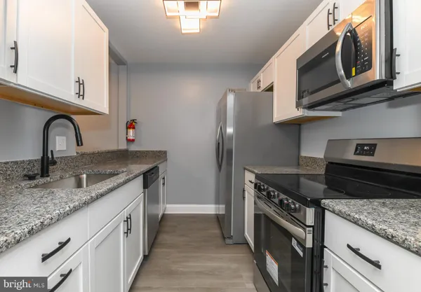 a bathroom with a granite countertop sink and a window