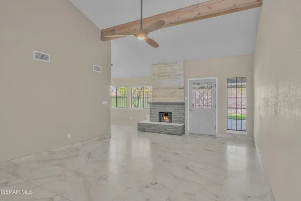 a view of an empty room with a fireplace and a window