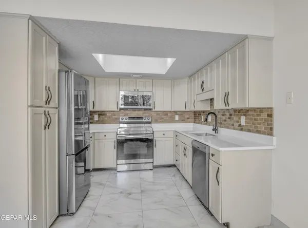 a kitchen with a sink stove oven and cabinets