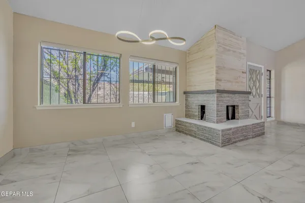 a view of an empty room with a fireplace and a window