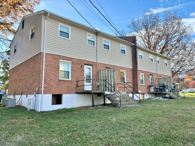 a front view of a house with a yard and trees