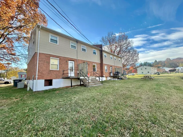 a view of a yard with a house and a large tree