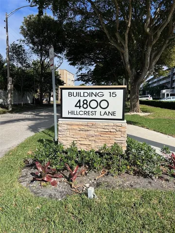 a sign that is sitting in front of a tree