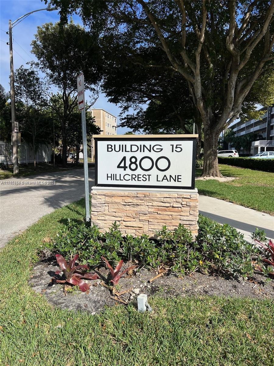 a sign that is sitting in front of a tree
