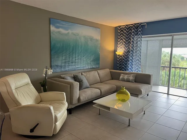 a living room with furniture and a floor to ceiling window