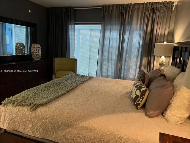 a bedroom with a bed lamp and a dresser