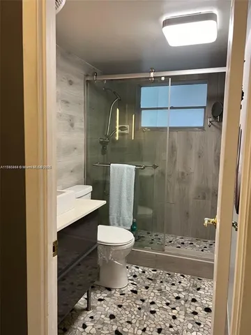 a bathroom with a sink a toilet and shower