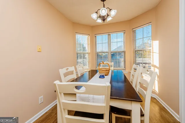 a view of a dining room with furniture a chandelier and wooden floor