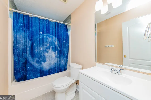 a bathroom with a sink a toilet and shower curtain