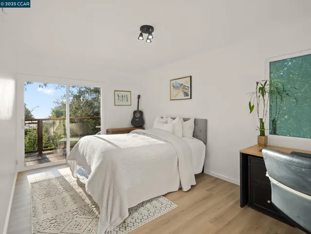a bedroom with a bed lamp and a large window