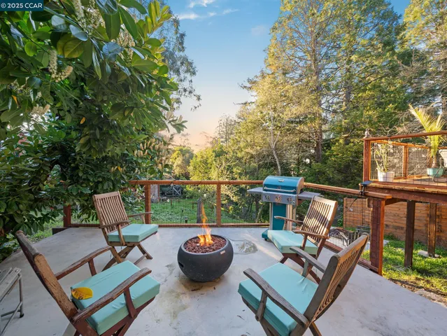 a view of a patio with a dining table and chairs with two plants