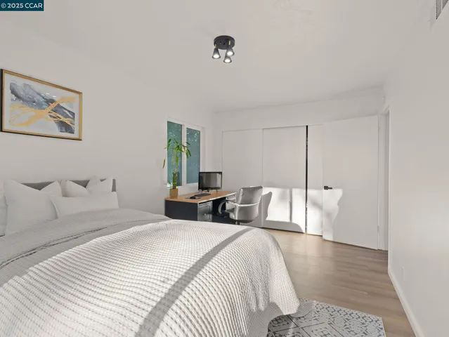 a bedroom with a bed a mirror and a large window