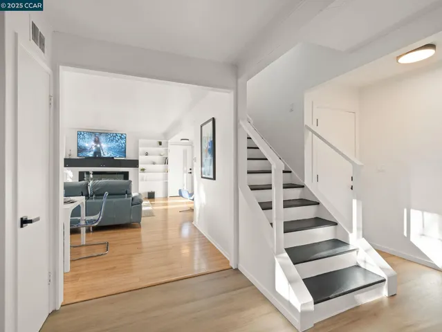 a view of entryway and hall with wooden floor