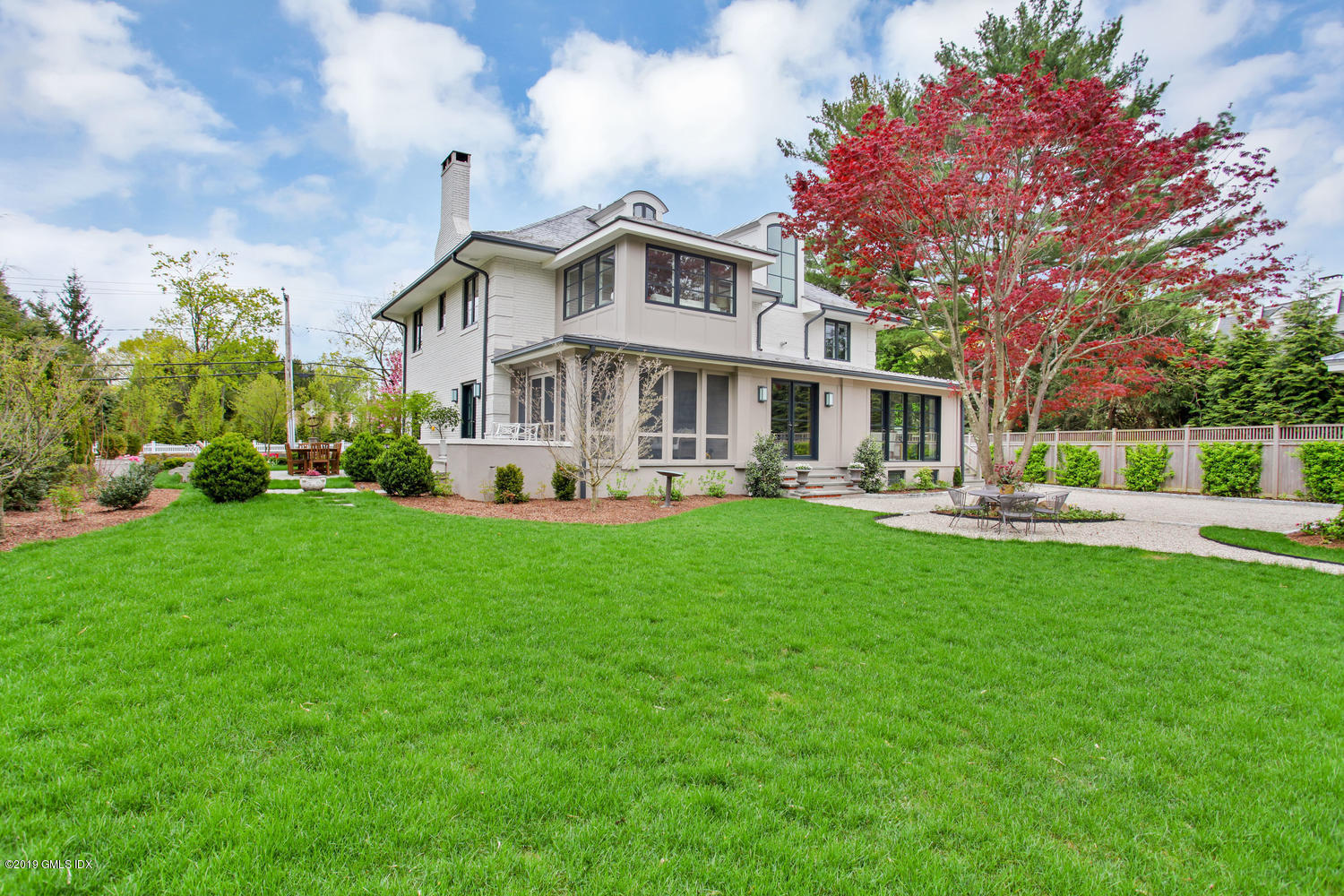 56 Old Church Road Greenwich, CT 06830 - Photo 33 of 41 a front view of a house with a yard table and chairs