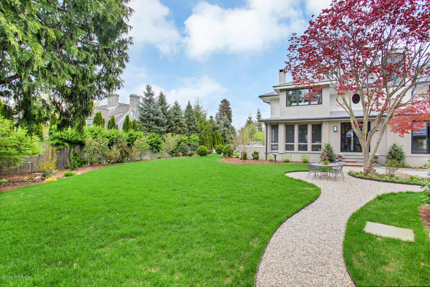56 Old Church Road Greenwich, CT 06830 - Photo 35 of 41 a front view of a house with a yard table and chairs