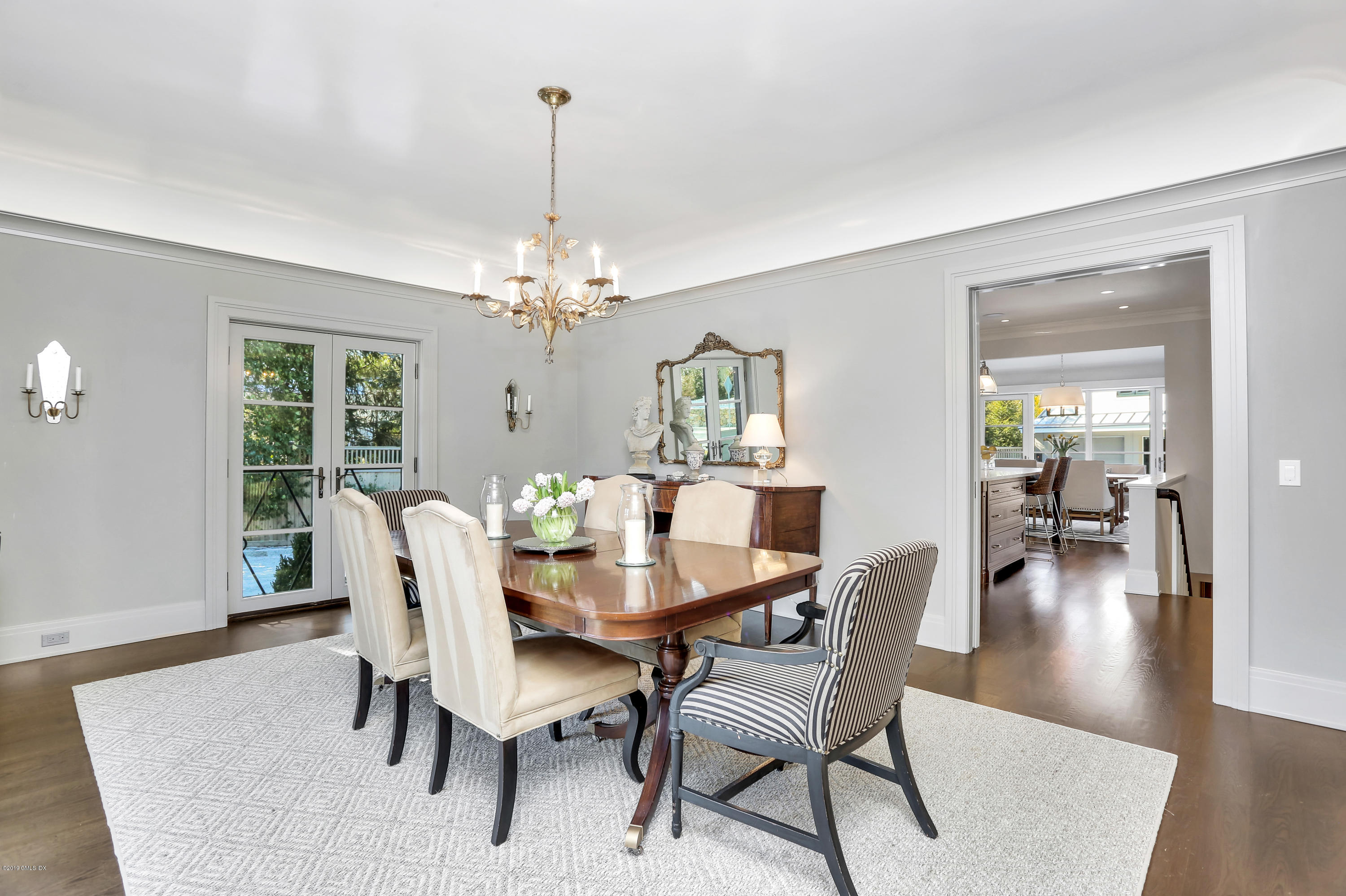 56 Old Church Road Greenwich, CT 06830 - Photo 9 of 41 a dining room with furniture wooden floor a rug and a chandelier