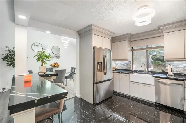 a kitchen with white cabinets and stainless steel appliances