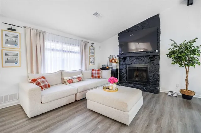 a living room with furniture a flat screen tv and a fireplace