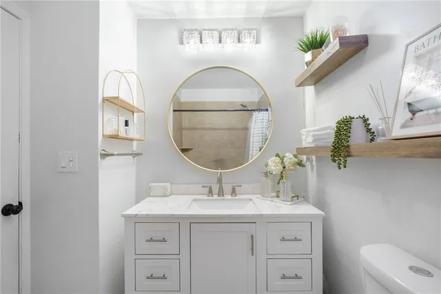 a bathroom with a granite countertop sink a mirror and vanity