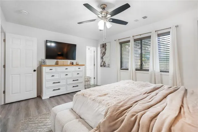 a spacious bedroom with a bed and a flat screen tv