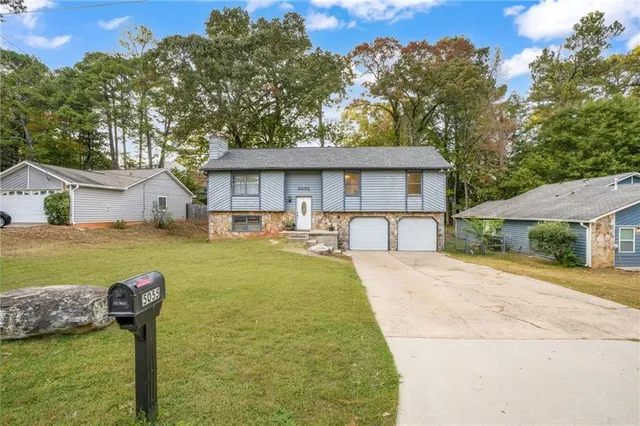a house view with swimming pool and trees in front of it