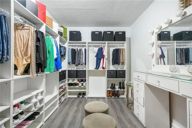 a view of walk in closet with clothes and shoes