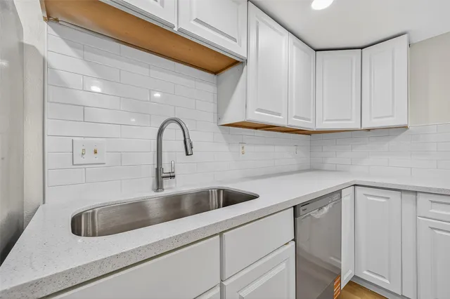 a close view of a sink a faucet cabinets and appliances
