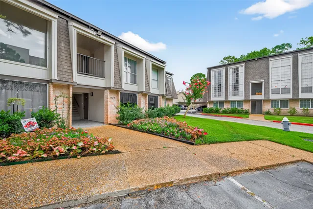 a front view of a house with a yard and potted plants