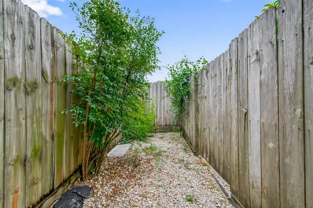 a view of a pathway gate with wooden fence