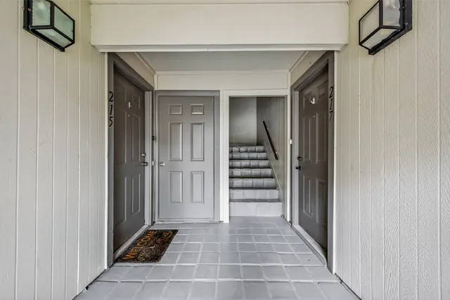 a view of a hallway with wooden cabinets and staircase