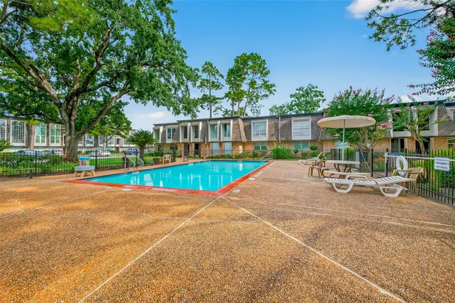 a view of a swimming pool with a patio and a yard