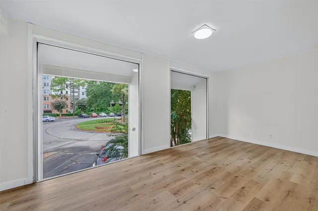 a view of an empty room with a window and a swimming pool