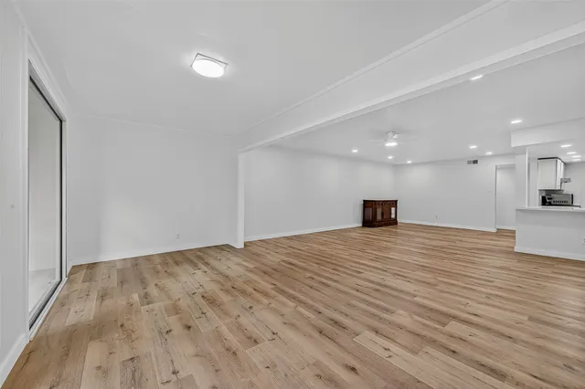 a view of empty room with wooden floor and a sink
