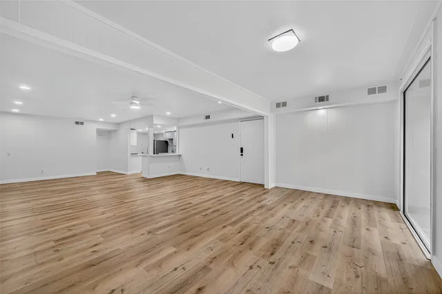 a view of empty room with wooden floor