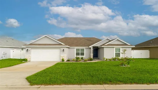 a front view of a house with a garden and yard
