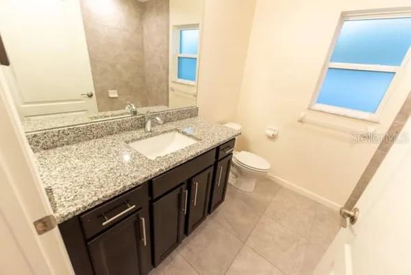 a bathroom with a granite countertop sink and a mirror